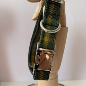 Green And Gold Tartan Dog Collar In A Wooden Hand
